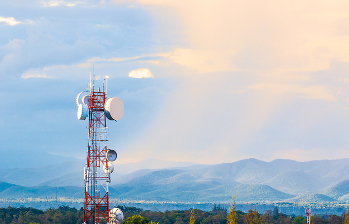 wireless communications tower with mountainous landscape in background